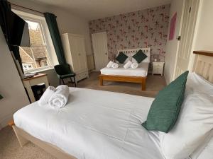 a bedroom with a large white bed in a room at The Coldstreamer Inn in Penzance +8 photos