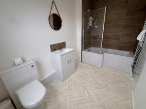a bathroom with a toilet and a sink and a shower at The Coldstreamer Inn in Penzance
