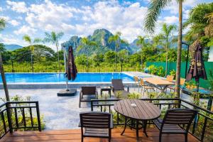 a patio with tables and chairs next to a pool at Nature Resort Vangvieng in Vang Vieng