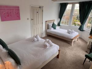 a bedroom with two beds with towels on them at The Coldstreamer Inn in Penzance