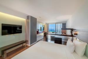a bedroom with a large bed and a television at RR Hotel da Rocha in Portimão