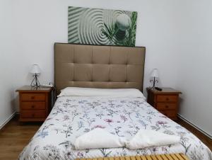 a bedroom with a large bed and two night stands at Pension Santa Rita in Santiago de Compostela