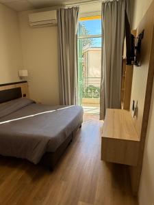 a bedroom with a bed and a large window at Hotel Esperia in Sanremo +50 photos