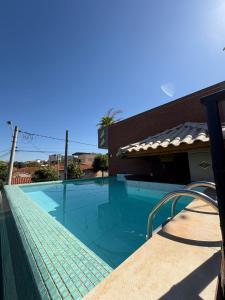 a swimming pool next to a building at Pousada Casa Limão in Rifaina