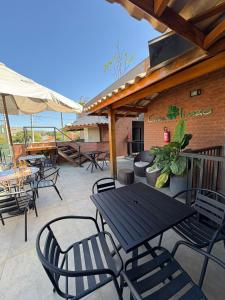 an outdoor patio with tables and chairs and the ocean at Pousada Casa Limão in Rifaina