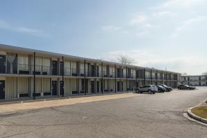 a large building with cars parked in a parking lot at Motel 6 Sherman, TX in Sherman