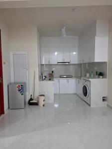 a kitchen with white cabinets and a washer and dryer at Deam Stay in Kulhudhuffushi +4 photos