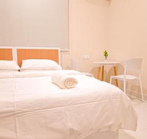 a white bed with a towel on top of it at Deam Stay in Kulhudhuffushi