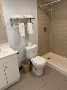 a white bathroom with a toilet and a shower at Motel 6 Sherman, TX in Sherman