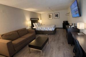 a hotel room with a bed and a couch at Motel 6 Sherman, TX in Sherman +22 photos