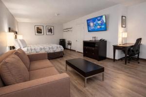 a living room with a couch and a bed and a desk at Motel 6 Sherman, TX in Sherman