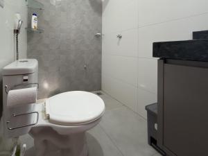 a bathroom with a white toilet and a sink at Flat Mobiliado no centro in Redenção +14 photos