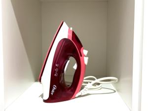 a red and white computer monitor with a cord at Flat Mobiliado no centro in Redenção