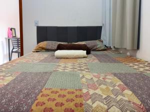 a large bed with a colorful quilt on it at Flat Mobiliado no centro in Redenção