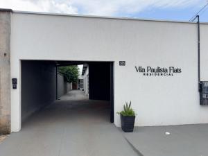 a white building with a tunnel with a sign on it at Flat Mobiliado no centro in Redenção