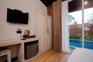 a living room with a tv and a large window at Sunsei Beach Negombo in Negombo