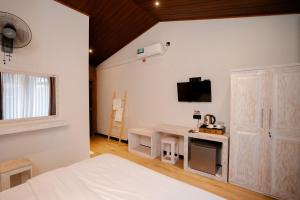 a bedroom with a bed and a desk with a tv at Sunsei Beach Negombo in Negombo