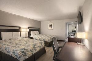 a hotel room with two beds and a table at Motel 6 Sherman, TX in Sherman