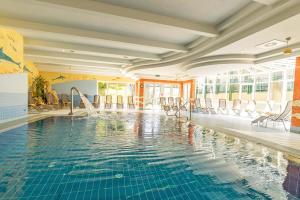 a swimming pool in a hotel with chairs around it at Hotel Schneeberghof in Puchberg am Schneeberg