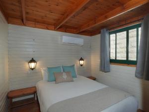 a bedroom with a bed with two lights on it at Lila in Bet Leẖem HaGelilit