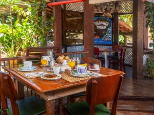 a wooden table with glasses of orange juice on it at Pousada Vila do Mar in Búzios