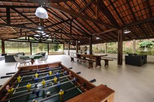 a room with a pool table and ping pong tables at Sítio dos Lagos in Domingos Martins