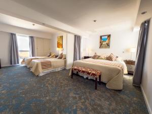 a hotel room with two beds and a window at GRAN PALAZZO Hotel in Villa Gesell