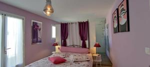 a bedroom with a bed with pink pillows at Chambres d'Hôtes Aube de Lune in Saint-Palais-sur-Mer