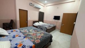 a hospital room with two beds and a tv at Amrit Guest House in Vrindāvan
