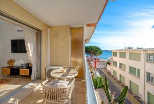 a balcony with a table and chairs and a view of the ocean at Studio vue Mer Alegria in Sainte-Maxime