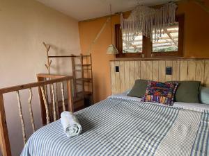 a bedroom with a bed with a striped comforter at Granja Tzikin in Tzununá