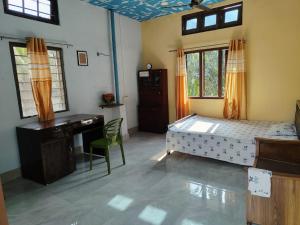 a bedroom with a bed and a desk and windows at Cozy Home in Guwahati