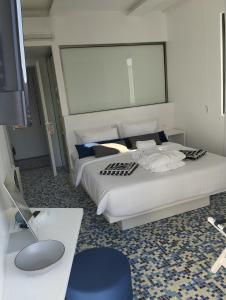 a bedroom with a large white bed and a desk at Ergina Boutique Experience in Sisi