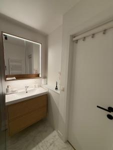 a bathroom with a sink and a mirror at Orion NorthSea Suite in Blankenberge