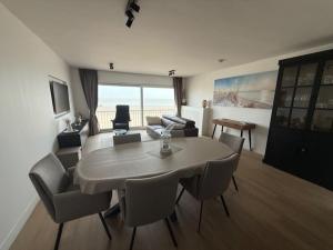 a living room with a dining room table and chairs at Orion NorthSea Suite in Blankenberge +9 photos