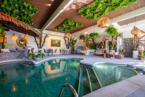 a pool in a hotel with tables and chairs at Hotel & Spa Poco a Poco - Costa Rica in Monteverde Costa Rica
