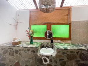 a bathroom with a green window and a sink at Granja Tzikin in Tzununá