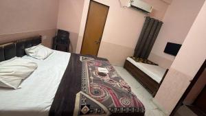 a bedroom with a bed and a mirror at Amrit Guest House in Vrindāvan +2 photos