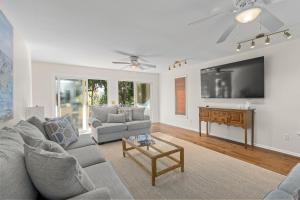 a living room with a couch and a tv at The Ugly Dolphin a Stylish Home for 12 in Edisto Island