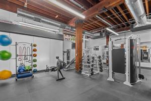 a gym with treadmills and machines in a room at Brick & Bed Riverfront Lofts, T 308 in Saint Louis
