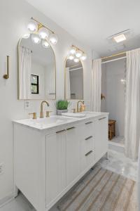 a white bathroom with two sinks and two mirrors at The Ugly Dolphin a Stylish Home for 12 in Edisto Island +70 photos