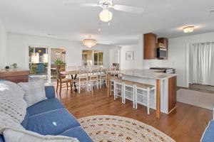 a living room with a blue couch and a kitchen at The Ugly Dolphin a Stylish Home for 12 in Edisto Island
