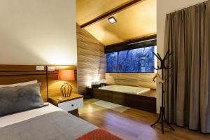 a bedroom with a bed and a tub in a window at Sítio dos Lagos in Domingos Martins +116 photos