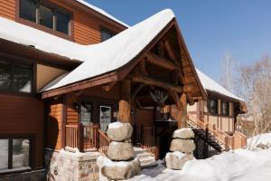a log cabin with snow on the roof at Lake view - Ski In-Out in Mont-Tremblant