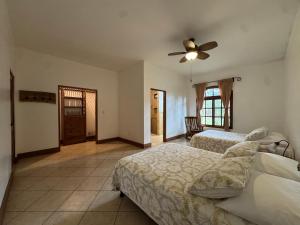 a bedroom with two beds and a ceiling fan at Van Kouwenhoven Hostel in Diriamba