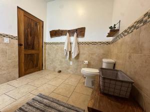 a bathroom with a toilet and a wooden door at Van Kouwenhoven Hostel in Diriamba +38 photos