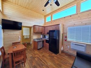 a kitchen with a black refrigerator and a table at Sun Outdoors Arches Gateway in Moab