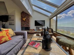 a living room with a couch and a large window at Deluxe Loft at Monteverde in Beit Meri
