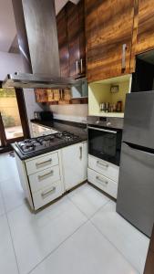 a kitchen with wooden cabinets and a stove top oven at Nivasa Villa - 5 BHK Triplex House Near Cyberhub in Gurgaon +14 photos