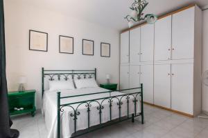 a bedroom with a bed with white walls and white cabinets at Downtown flat historic Reggio in Reggio di Calabria